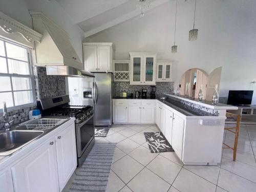 a kitchen with white cabinets and stainless steel appliances at Grace's Place in Sapphire