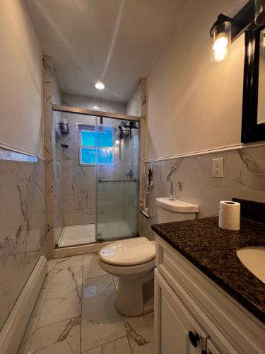 a bathroom with a toilet and a glass shower at Preston Serenity Room With Shared Bath & Kitchen in Hartford