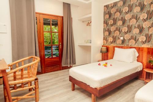 a bedroom with a bed and a chair at Eden Valley Ecolodge and Farming in Madalena