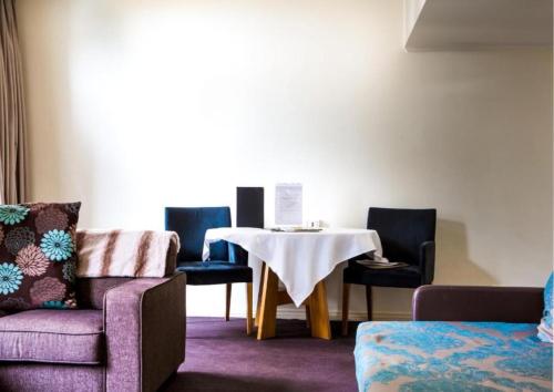 a room with a table and chairs and a table and a table and chairs at The Richmond Hotel - Adelaide in Adelaide