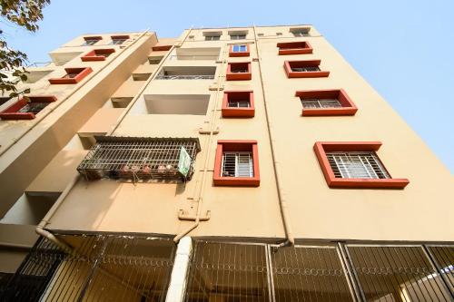 ジャムシェードプルにあるHotel O Creation Premiumの赤い窓のある白い高い建物