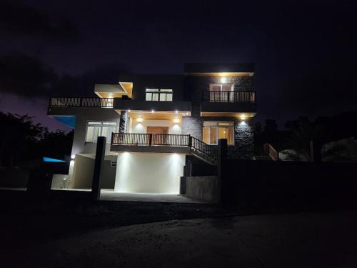 a night view of a house with lights at Setsuna, Luxury Oceanic View Villa Near Airport in Vieux Fort