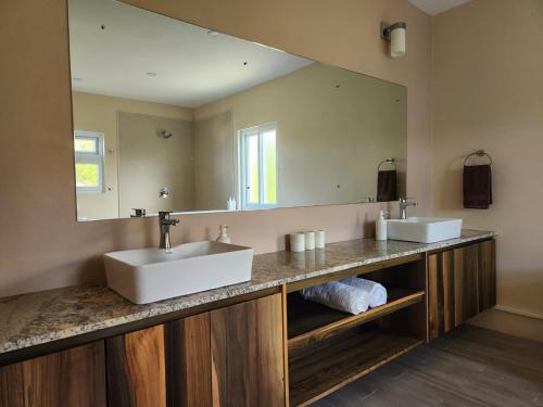 a bathroom with two sinks and a large mirror at Setsuna, Luxury Oceanic View Villa Near Airport in Vieux Fort