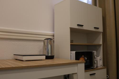 a kitchen counter with a coffee maker and a microwave at MIDIS - Local Accommodation in Lisbon