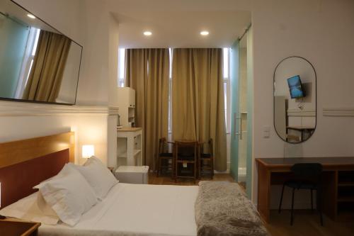 Un dormitorio con una cama, un escritorio y un espejo. en MIDIS - Local Accommodation, en Lisboa