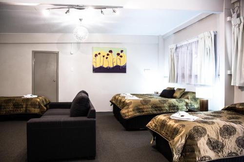 a hotel room with two beds and a couch at Tall Trees Motel Mountain Retreat in Mount Tamborine