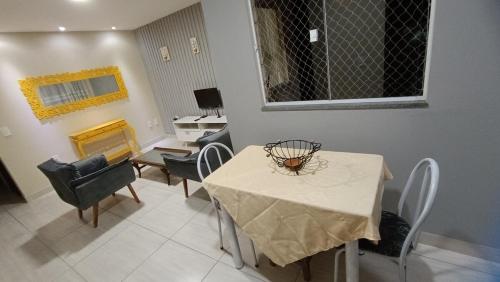 a dining room with a white table and chairs at Apartamento Bela vista Aperibé in Aperibé