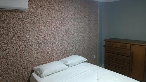 a bedroom with a bed and a wooden dresser at Apartamento Bela vista Aperibé in Aperibé