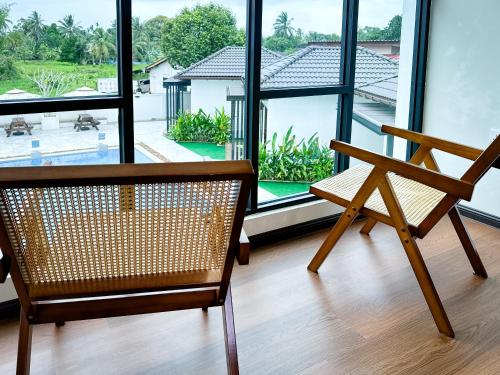 a wooden chair sitting in front of a large window at Smilang Chalet in Kuala Terengganu