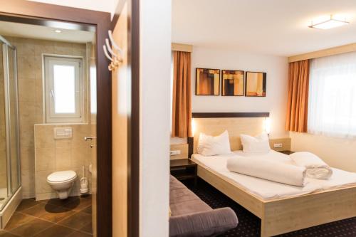 a hotel room with a bed and a bathroom at A Casa Kristall in Sölden