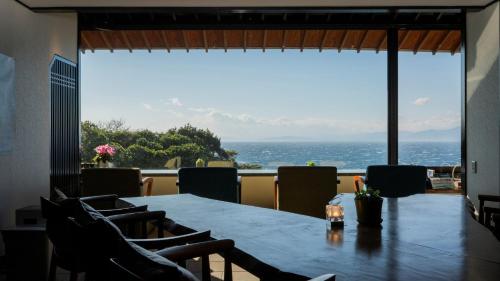 a dining room with a table and a view of the ocean at Nishiizu Koyoi in Numazu