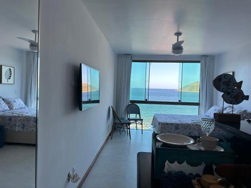 a bedroom with a bed and a view of the ocean at Arraial do cabo loft prainha in Arraial do Cabo