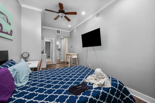 a bedroom with a blue bed with a ceiling fan at Modern & Chic Montrose Studio - Prime Location & Free Parking in Houston