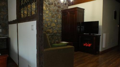 Una sala de estar con chimenea y televisión. en Apartamentos Legado de Santillana, en Santillana del Mar