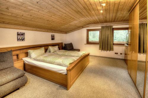 a bedroom with a bed and a chair in it at Haus Brandner in Viehhofen