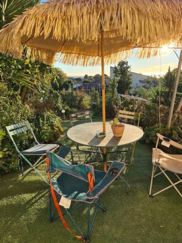 une table et des chaises sous un parasol en paille dans l'établissement flat with sea view, à Antibes