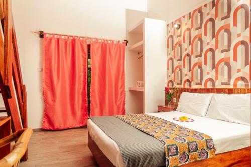 a bedroom with a bed and a red curtain at Eden Valley Ecolodge and Farming in Madalena