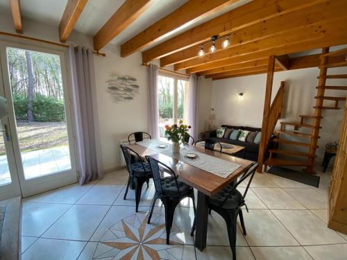 une salle à manger avec une table et des chaises en bois dans l'établissement holiday home, Grayan-et-l'Hôpital, à Grayan-et-lʼHôpital