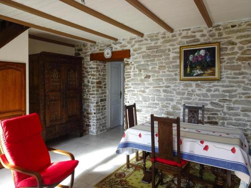a room with a table and chairs and a stone wall at Holiday Home by Kerleven Beach, France in La Forêt-Fouesnant