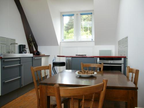 - une cuisine avec une table en bois, des chaises, une table et un bol de fruits dans l'établissement Flat in Plougasnou with Sea Views & Beaches, à Plougasnou