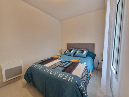 une chambre avec un lit avec des draps bleus et une fenêtre dans l'établissement Apartment in Belz near the Sea, à Belz