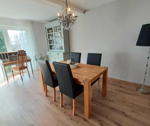 a dining room with a wooden table and chairs at Ferienwohnung Stadt-Land-Fluss in Bad Salzuflen