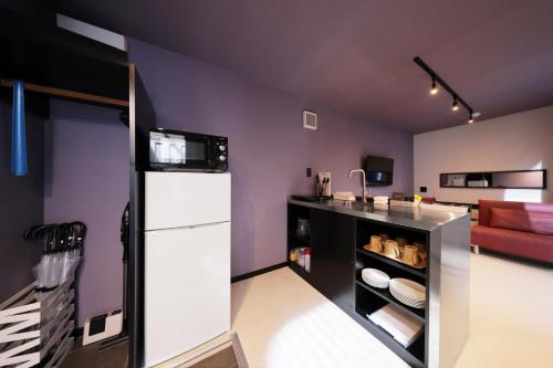 a kitchen with purple walls and a refrigerator at クリスタルパーク久松 in Miyako Island