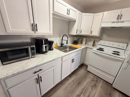a white kitchen with a sink and a microwave at Downtown Apt 5 Min Walk to Downtown - Free Parking in Las Vegas
