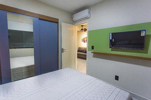 a bedroom with a bed and a tv on the wall at Residencial Bianca, Ap 07 - TERREO in Aracaju