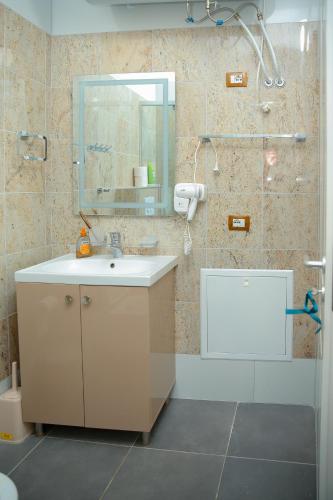 a bathroom with a sink and a shower with a mirror at Fishta apartments Q5 32 in Velipojë