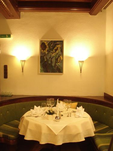 a table with wine glasses and a painting on the wall at Gasthof Einhorn Schaller in Schwaz