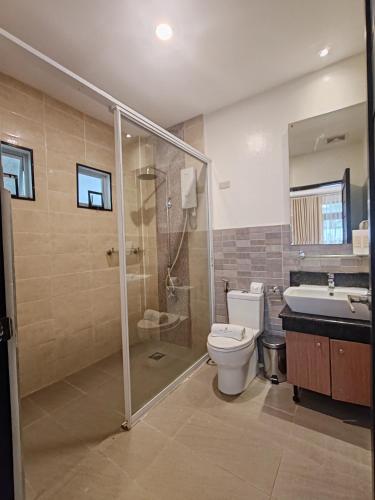 a bathroom with a shower and a toilet and a sink at The Zen Villas Resort in Lipa