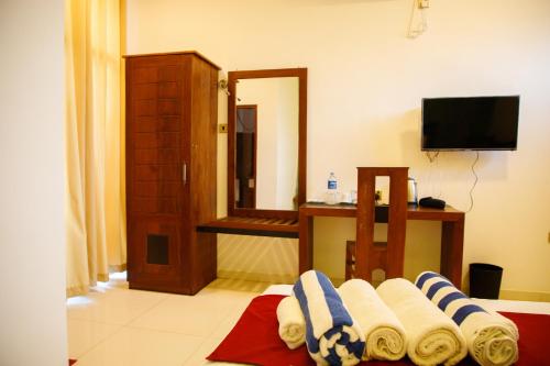 a bathroom with towels on the floor and a mirror at Monaara Leisure - Anuradhapura in Anuradhapura