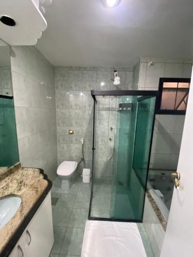 a bathroom with a glass shower and a toilet at Casa em Itapuã pertinho da praia in Vila Velha