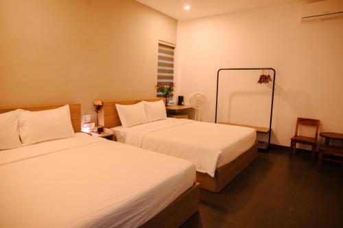 ein Hotelzimmer mit zwei Betten und einem Spiegel in der Unterkunft Charm House Hue in Hue