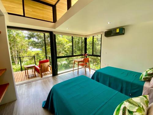 a bedroom with two beds and a balcony at Sinfonía Tropical, ocean view, 5 minutes driving to Playa Linda, 15 to Dominical, wifi Starlink in Savegre