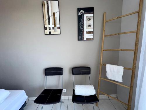 - une chambre avec deux chaises et une échelle dans l'établissement Appartement rénové à Saint-Hilaire-de-Riez, parking privé, proche plage et commerces - FR-1-323-258, à Saint-Hilaire-de-Riez