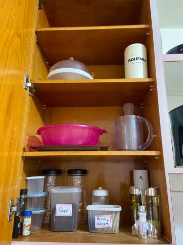 a cupboard with dishes and other kitchen utensils at Casa em Itapuã pertinho da praia in Vila Velha