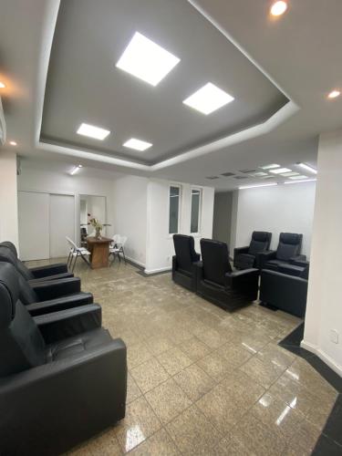 a conference room with black chairs and a podium at Casa em Itapuã pertinho da praia in Vila Velha