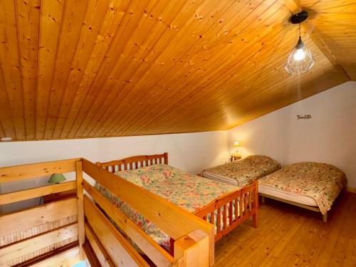 deux lits dans une chambre avec un plafond en bois dans l'établissement Maison spacieuse à 300m de la plage avec terrasse, pour 6 pers., Saint-Hilaire-de-Riez - FR-1-323-378, à Saint-Hilaire-de-Riez