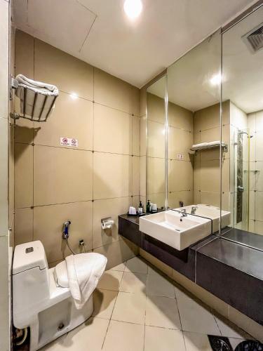 a bathroom with a toilet and a sink at Courtyard Hotel 1Borneo in Kota Kinabalu