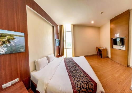 a hotel room with a large bed and a television at Courtyard Hotel 1Borneo in Kota Kinabalu