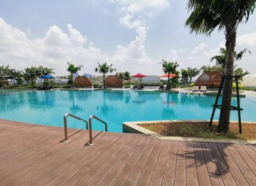 a swimming pool at a resort with a palm tree at Almas 2Pax Cozy Serene Grey Puteri Harbour BySTAY in Iskandar Puteri