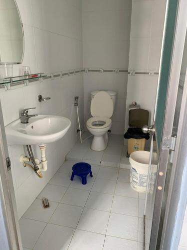 a white bathroom with a toilet and a sink at Hữu Đặng in Chau Doc