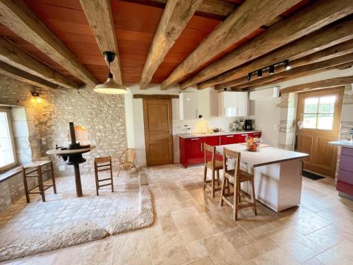 Il comprend une cuisine avec des plafonds en bois, une table et des chaises. dans l'établissement Gîte paisible avec jardin à Chédigny - FR-1-381-611, à Chédigny