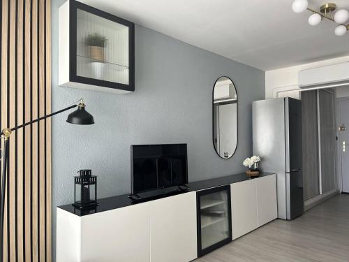 - un salon avec une télévision et un réfrigérateur dans l'établissement Studio rénové face mer avec parking, au Cap d'Agde - FR-1-723-172, au Cap d'Agde