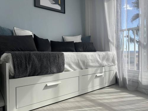 une chambre avec un lit blanc avec une fenêtre dans l'établissement Studio rénové face mer avec parking, au Cap d'Agde - FR-1-723-172, au Cap d'Agde