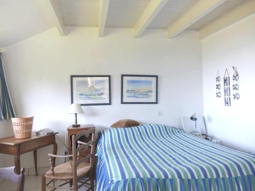 Un dormitorio con una cama, una silla y una mesa. en Maison spacieuse à 400m de la plage des Govelins, vue mer - FR-1-639-138, en Saint-Gildas-de-Rhuys