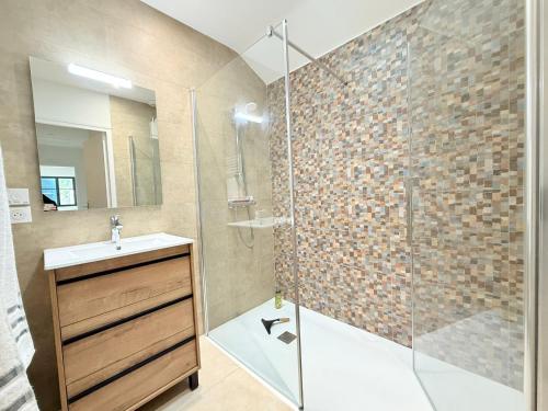 La salle de bains est pourvue d'une douche, d'un lavabo et d'une porte en verre. dans l'établissement Maison neuve à 300m de la plage pour 4 pers, St-Pierre-d'Oléron - FR-1-778-42, à Saint-Pierre-dʼOléron