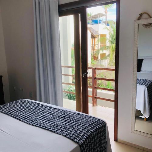 Un dormitorio con una cama y un espejo y un balcón. en Suite Front Jeri, en Jericoacoara